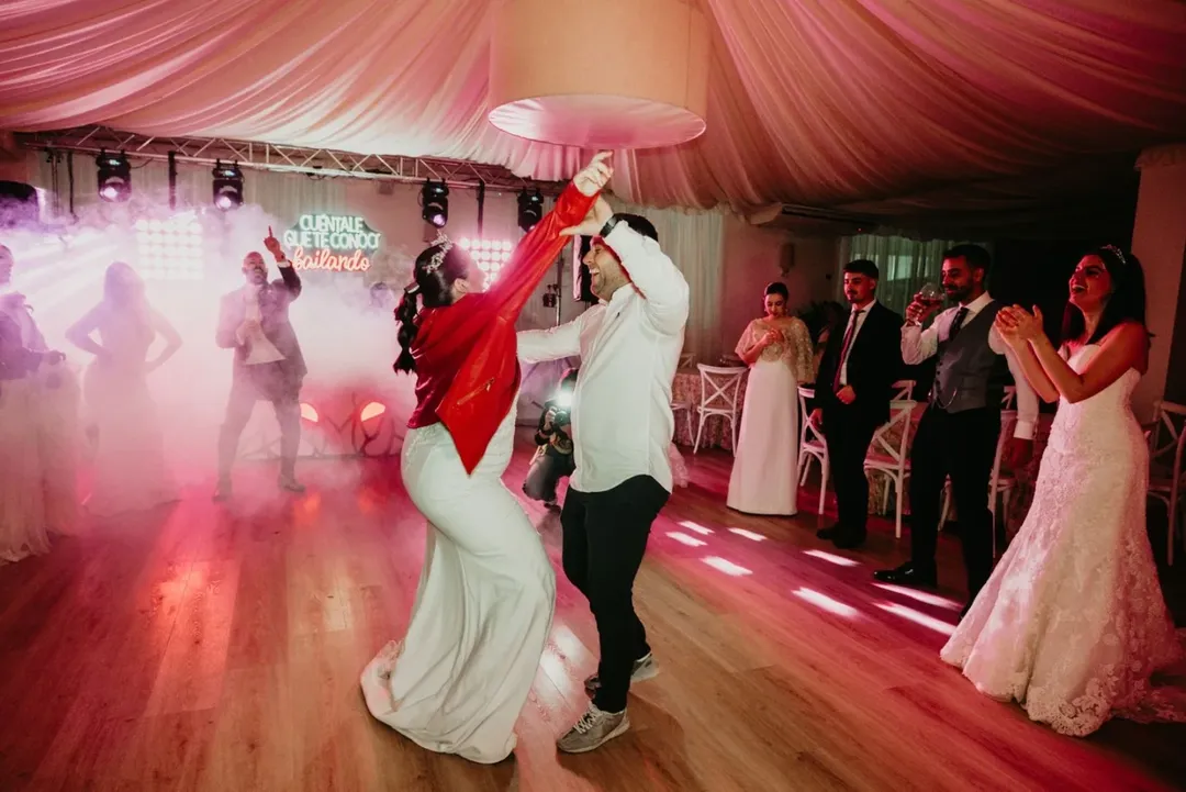 Novios e invitados bailando y disfrutando al máximo en la pista de baile, reflejando las excelentes opiniones de los clientes de Wild Music Sevilla.