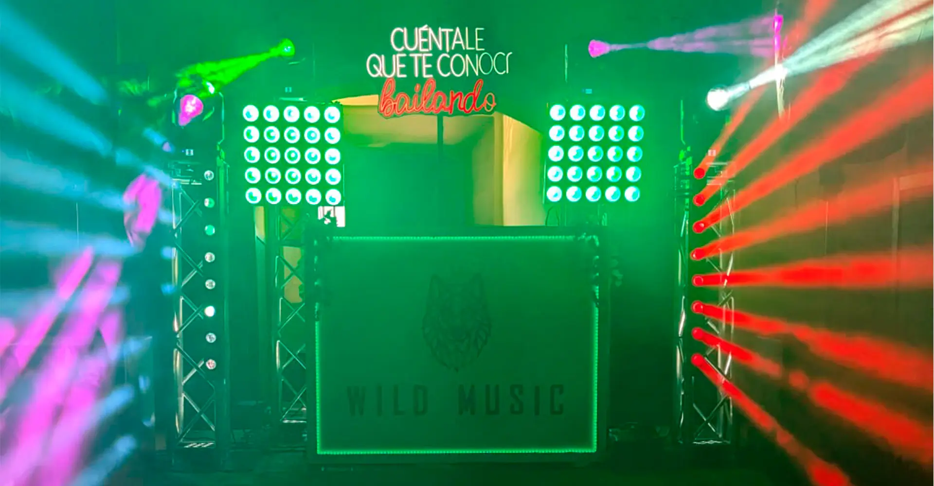 Montaje Set Deluxe de Wild Music con cabina iluminada verde, totems truss, cabezas móviles, efectos LED y sonido profesional para bodas y eventos exclusivos.