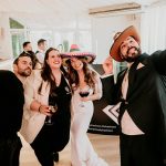 Invitados disfrutando y haciéndose un selfie con divertidos sombreros durante la animación de una boda con Wild Music Sevilla.