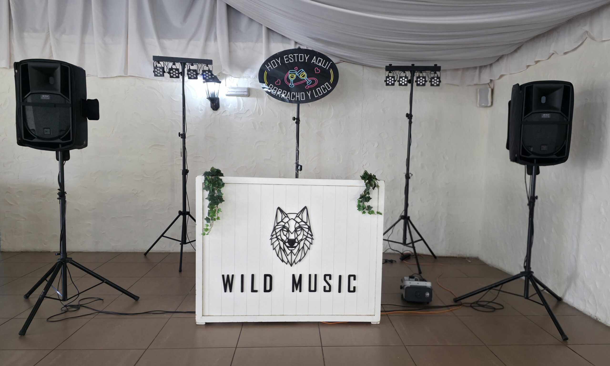 Elegante cabina de madera blanca con el logo de Wild Music Sevilla, equipo de sonido y luces del Set Estándar para celebraciones.